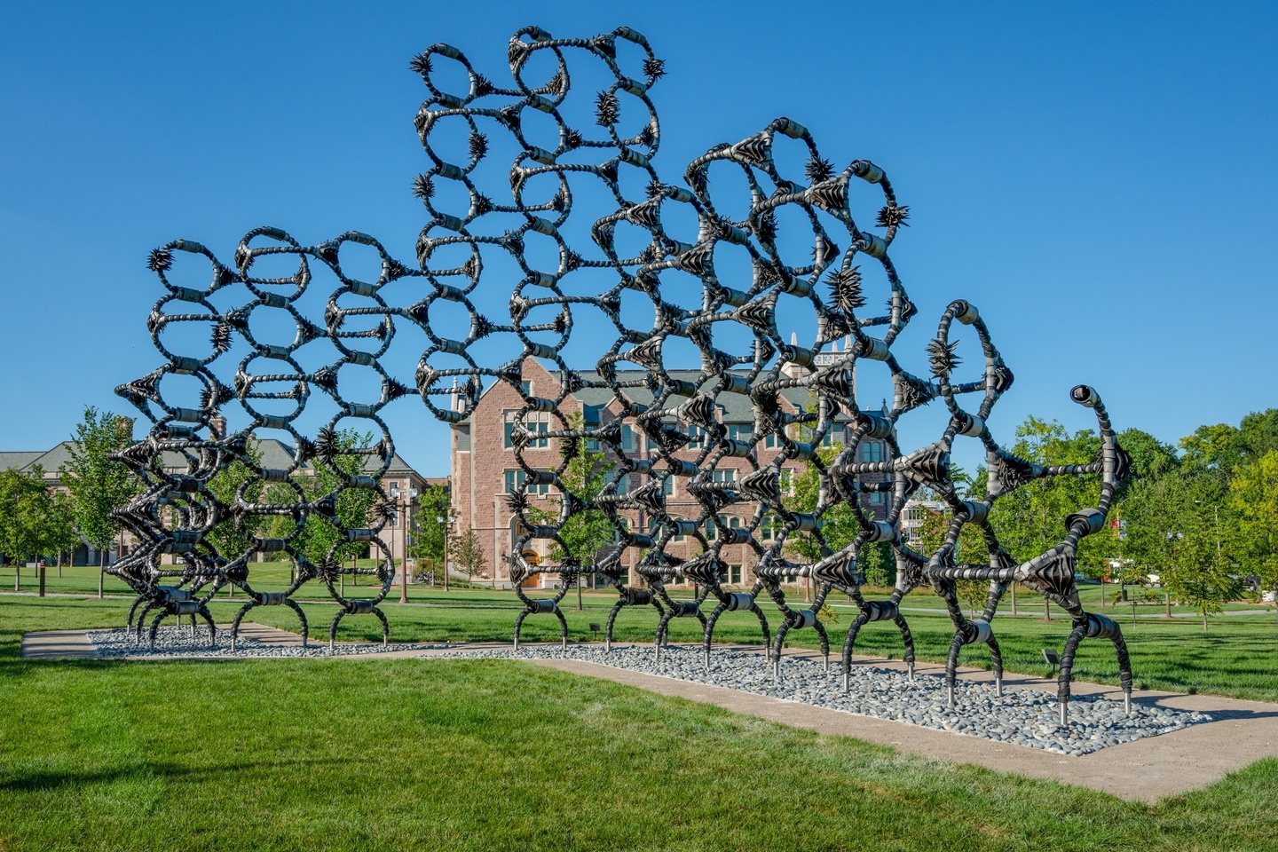 A large, outdoor sculpture composed of circular modules made of pieces of rubber tires