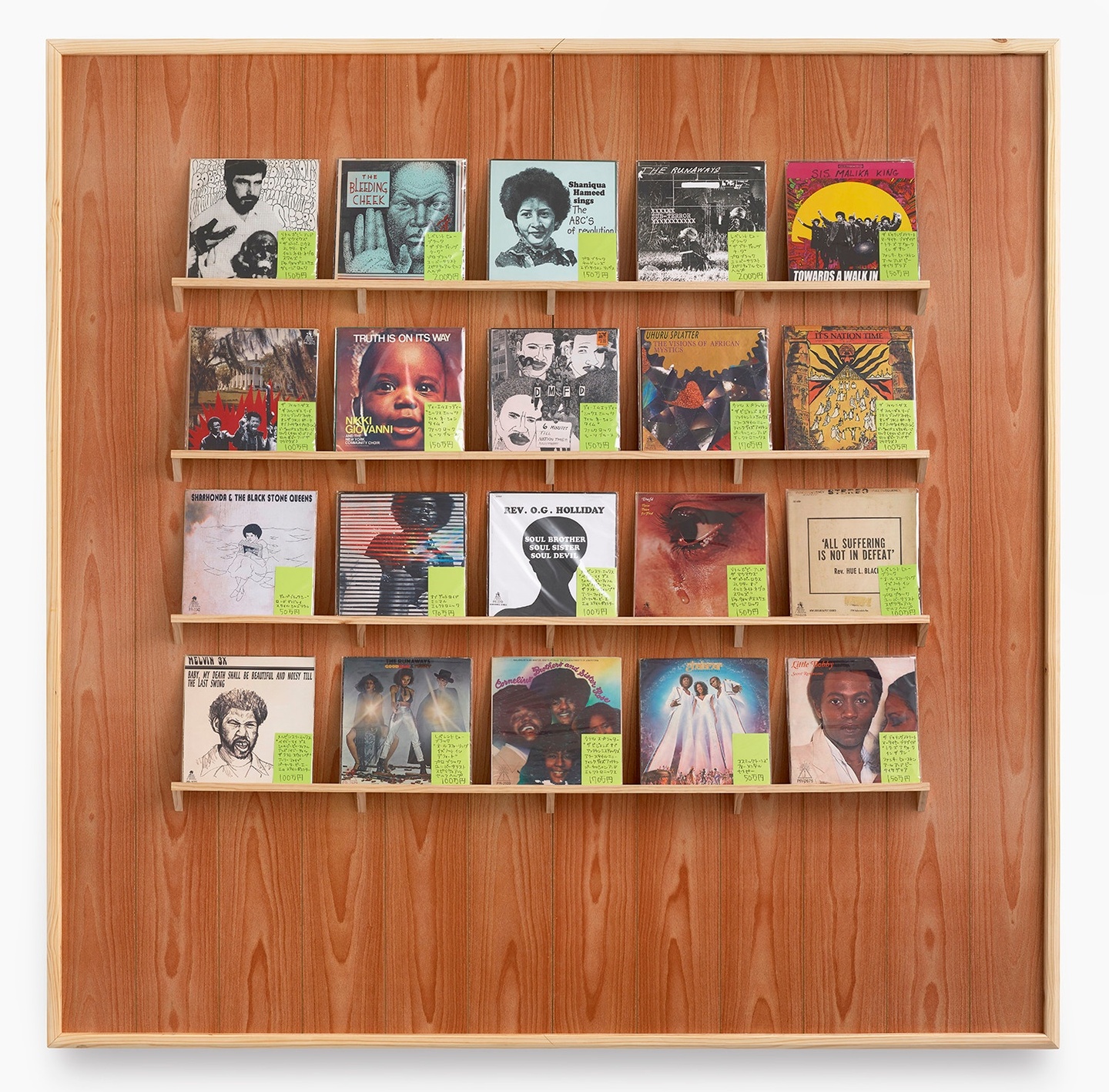 Collage on paper, wood paneling, wood shelving, plastic bags, featuring five rows of four record covers.