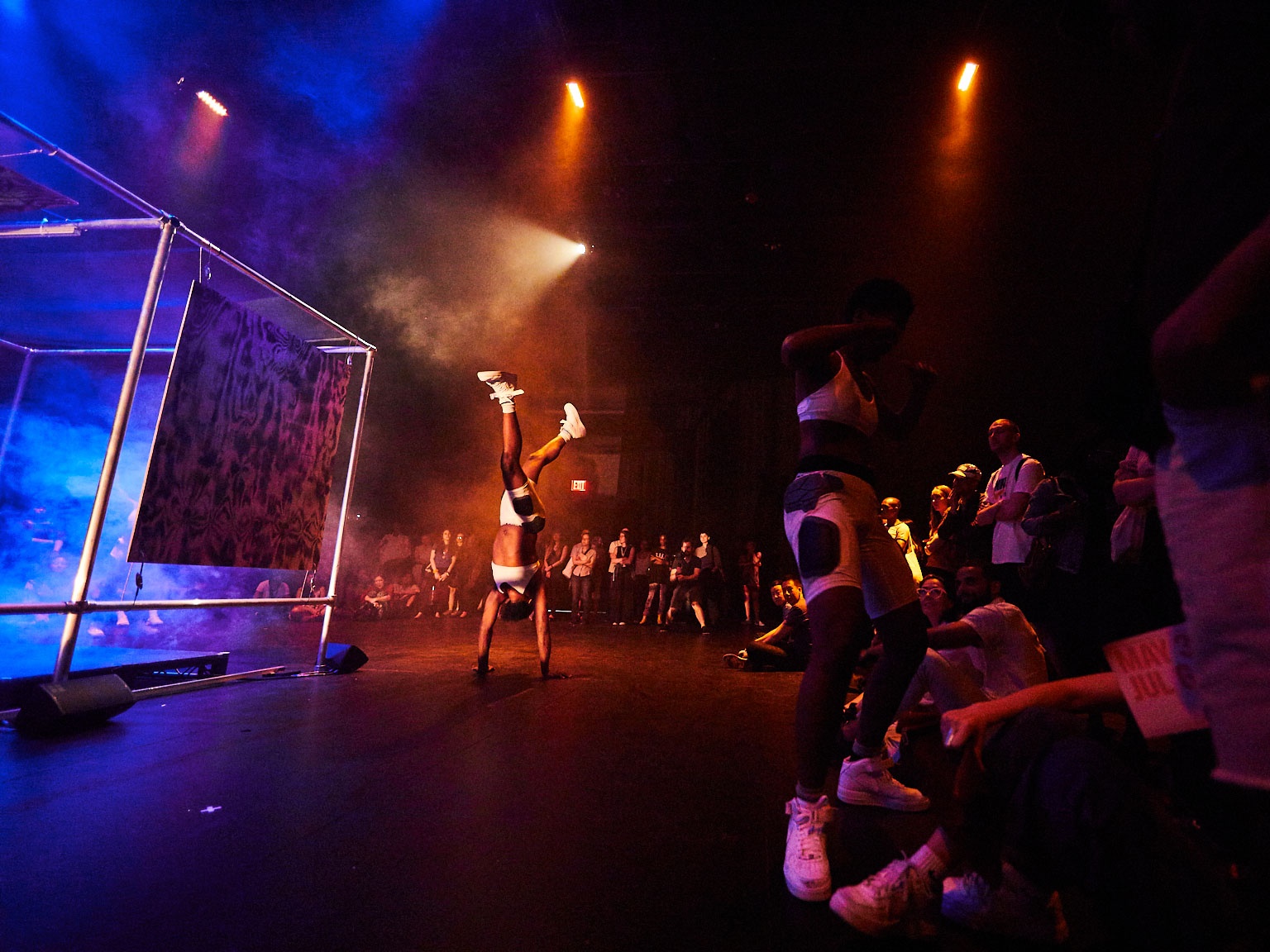 Dancers on a dramatically lit stage in front of a crowd.