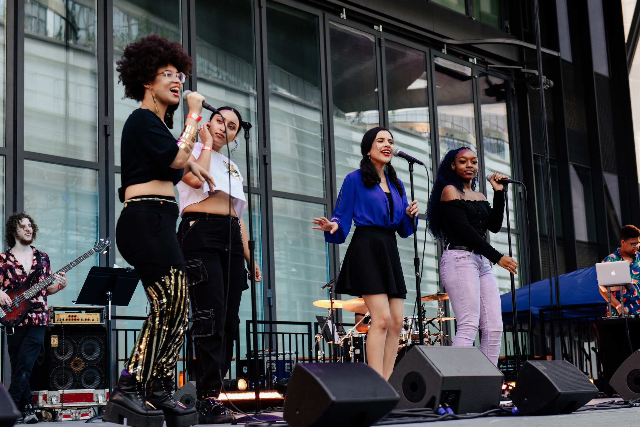 Singers singing on outdoor stage.