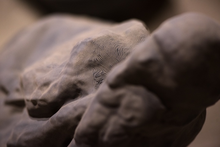 Close up photo of a greyish organically shaped object that is made up of topographic sections.