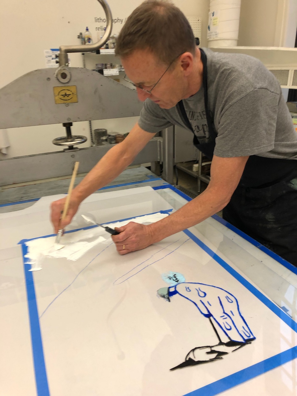 David adding white details onto the transparent sheet with a large brush and a palette knife