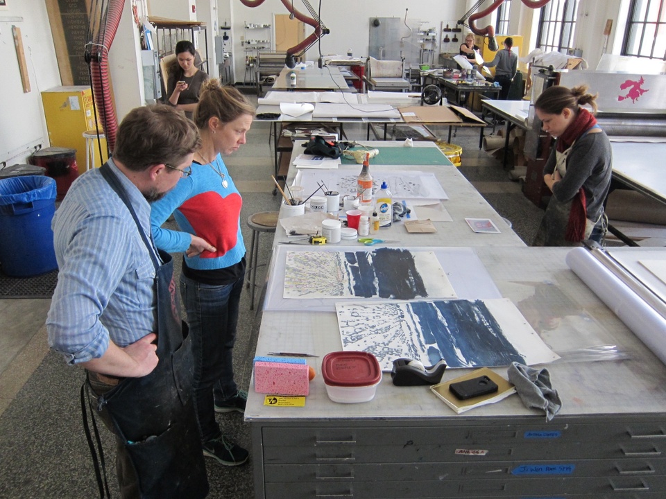 printer and artist looking at drawing materials on table