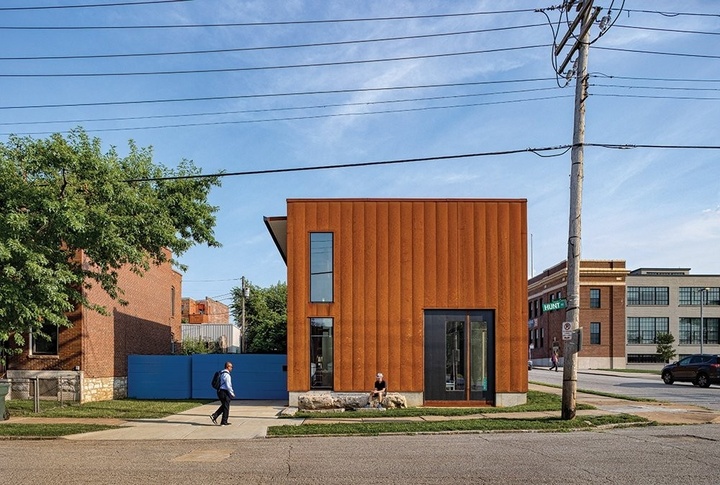 Square house made of steel that has oxidized into an orange color