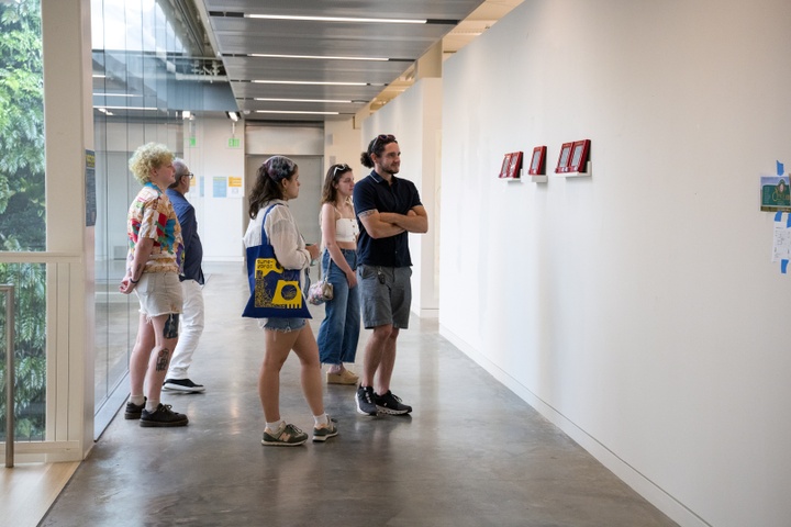 Visitors peruse 4 etch-a-sketchs on display 