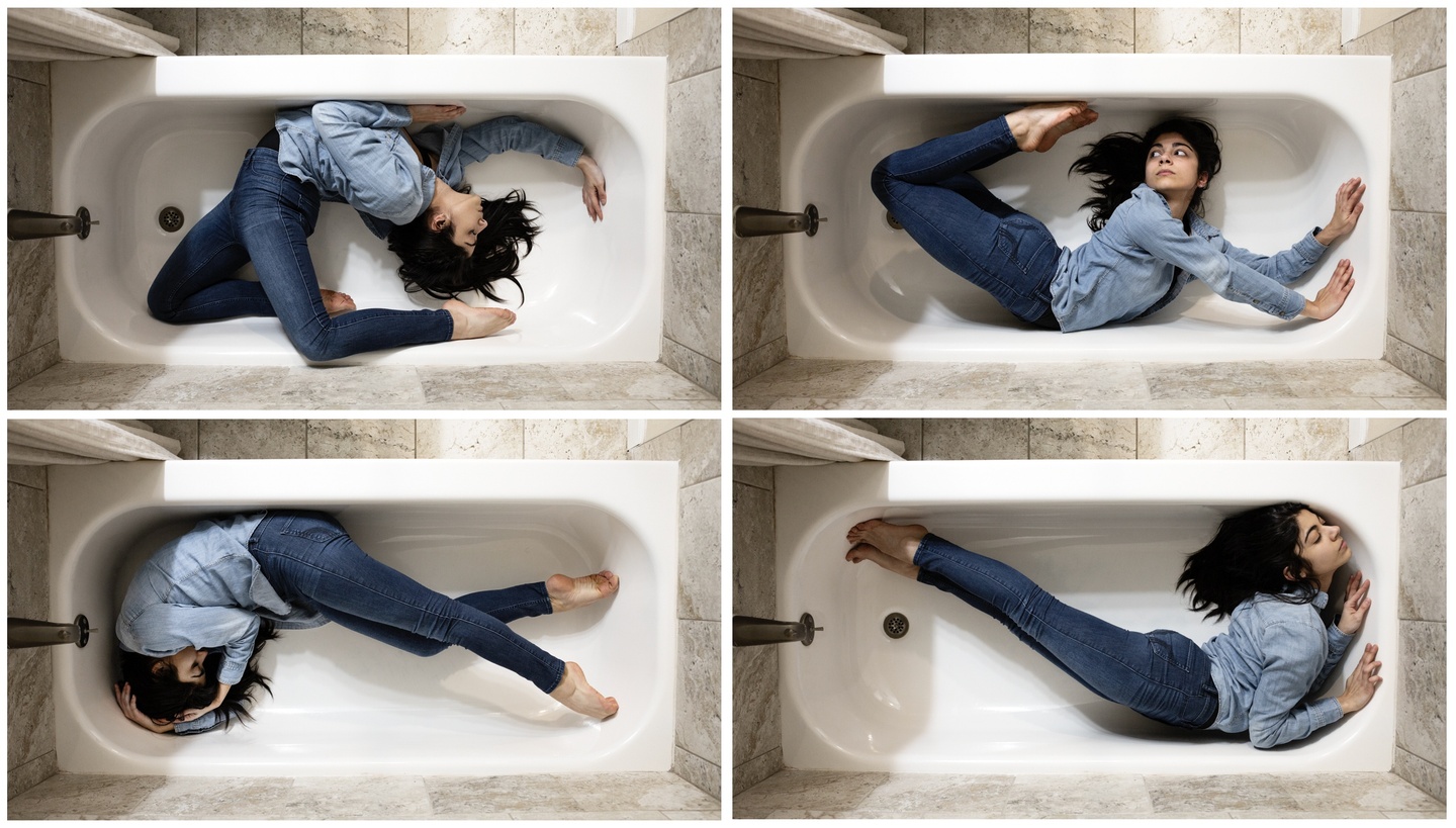 Grid of four images, all overhead views of a bathtub. A person in jean leggings and a jeans shirt contorts into different, very flexible positions lying inside the tub.