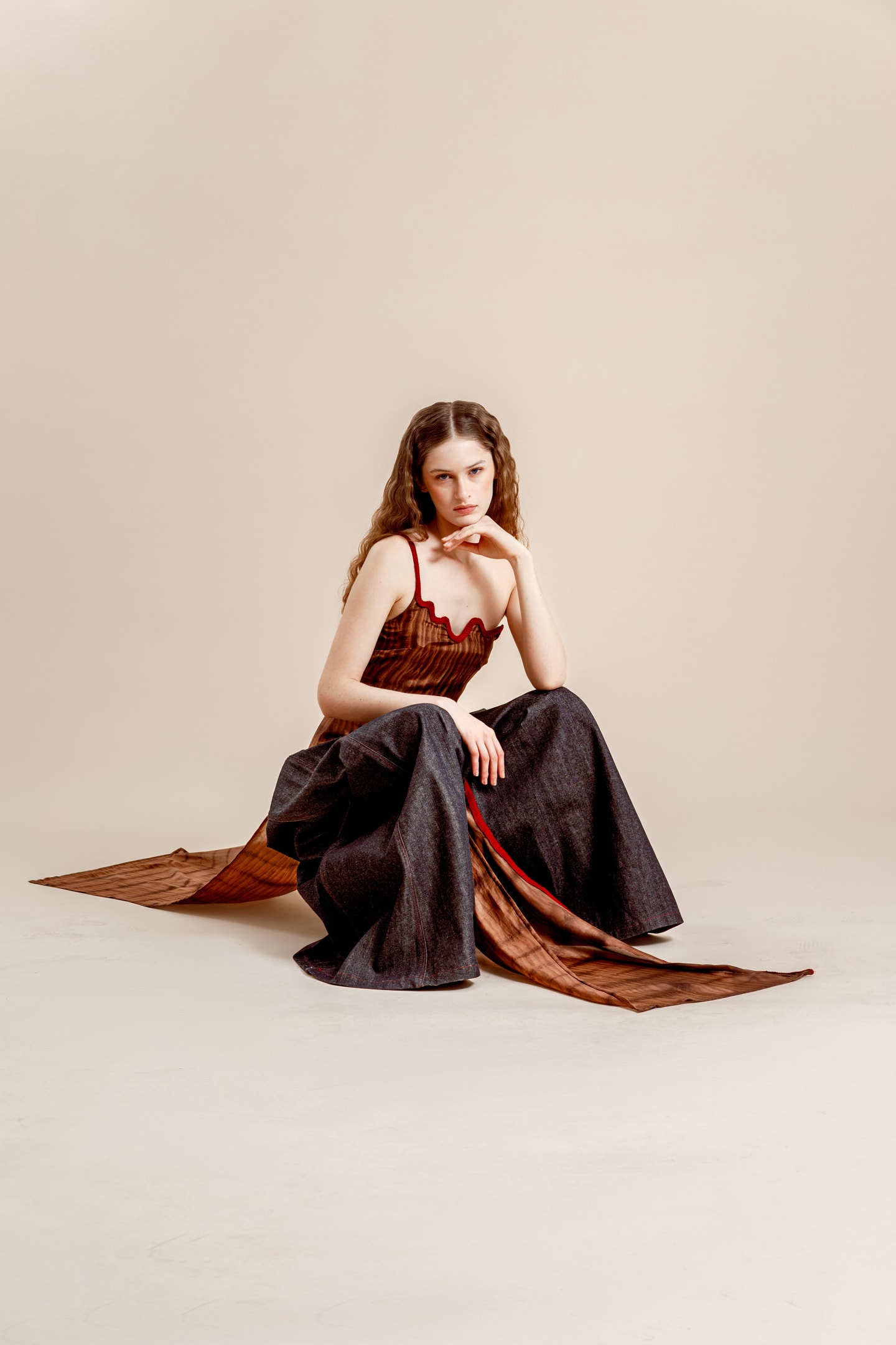 model sitting on the floor in black and red dress