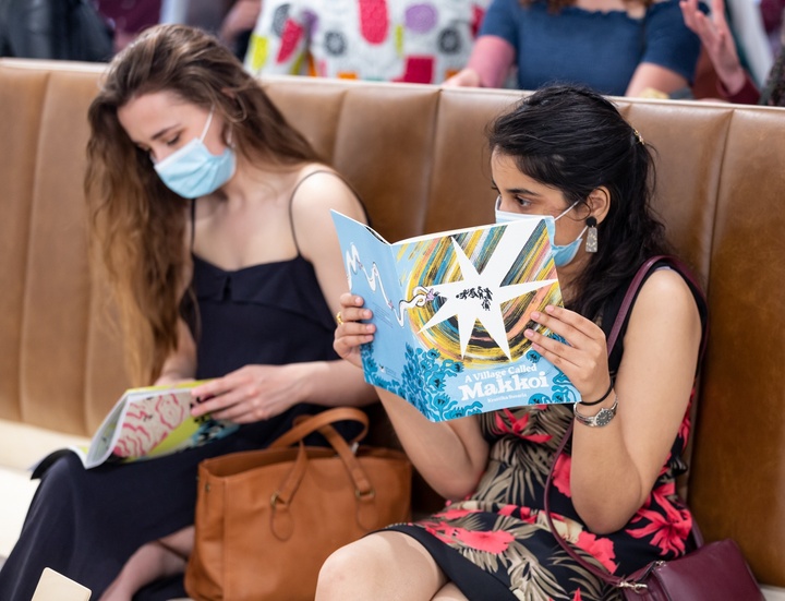 A visitor holds up a book by Kruttika Susarla