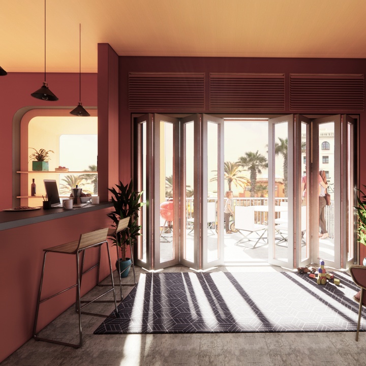 Interior view of a room with a bar on the left looking out at a patio with tables and chairs