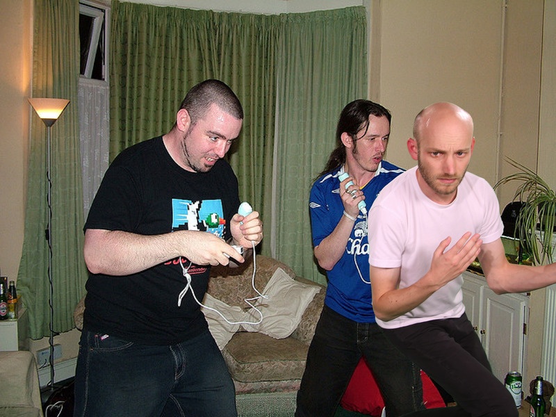 A photo from Sam Lavigne's Open Call commission Training Poses depicting Two men playing a game with controllers.