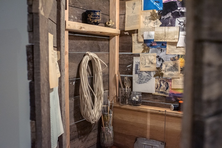 Detail of a little wooden room, the size of an outhouse, filled with ropes and papers and ephemera.
