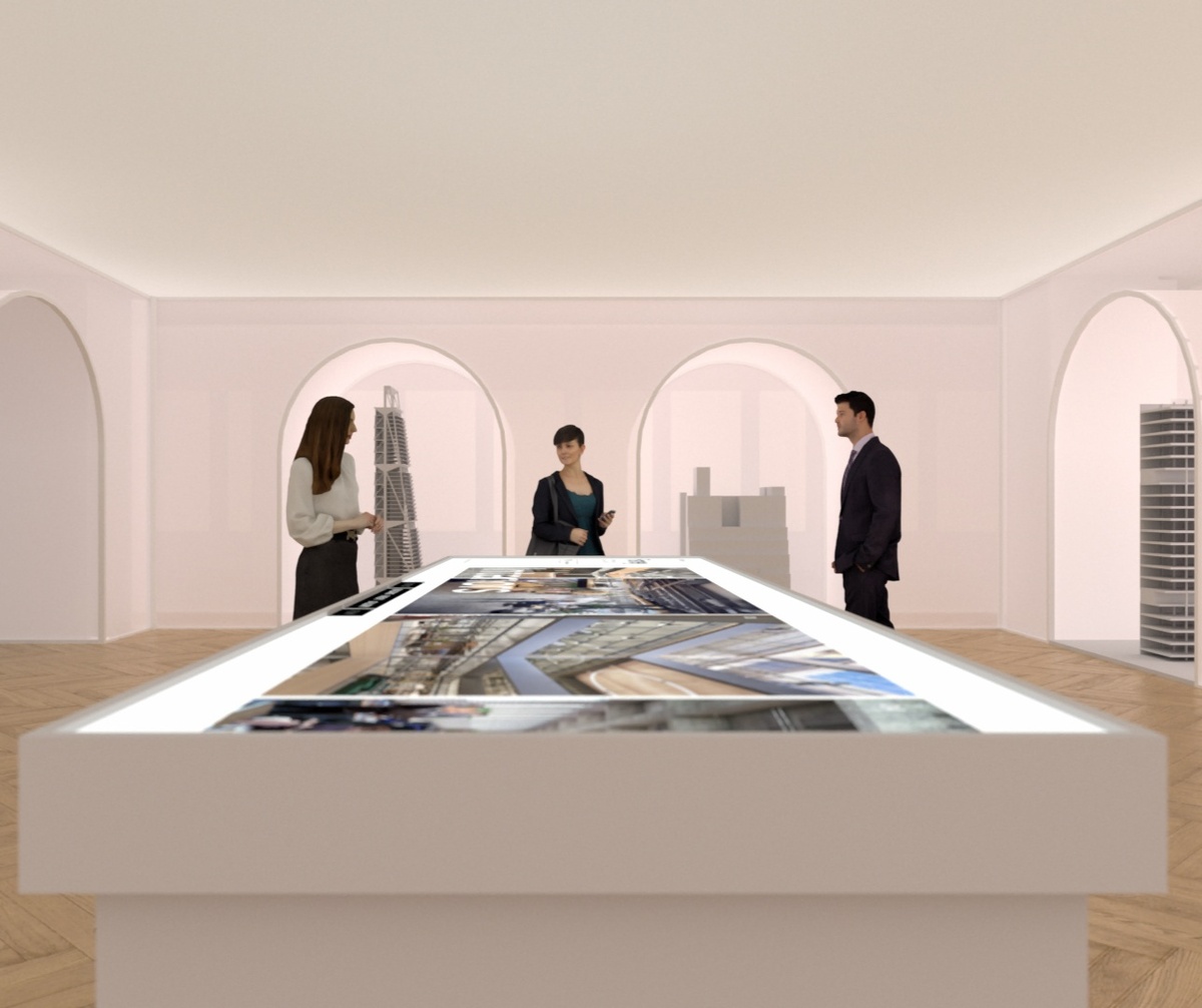 People standing around digital table, with architectural models in the background