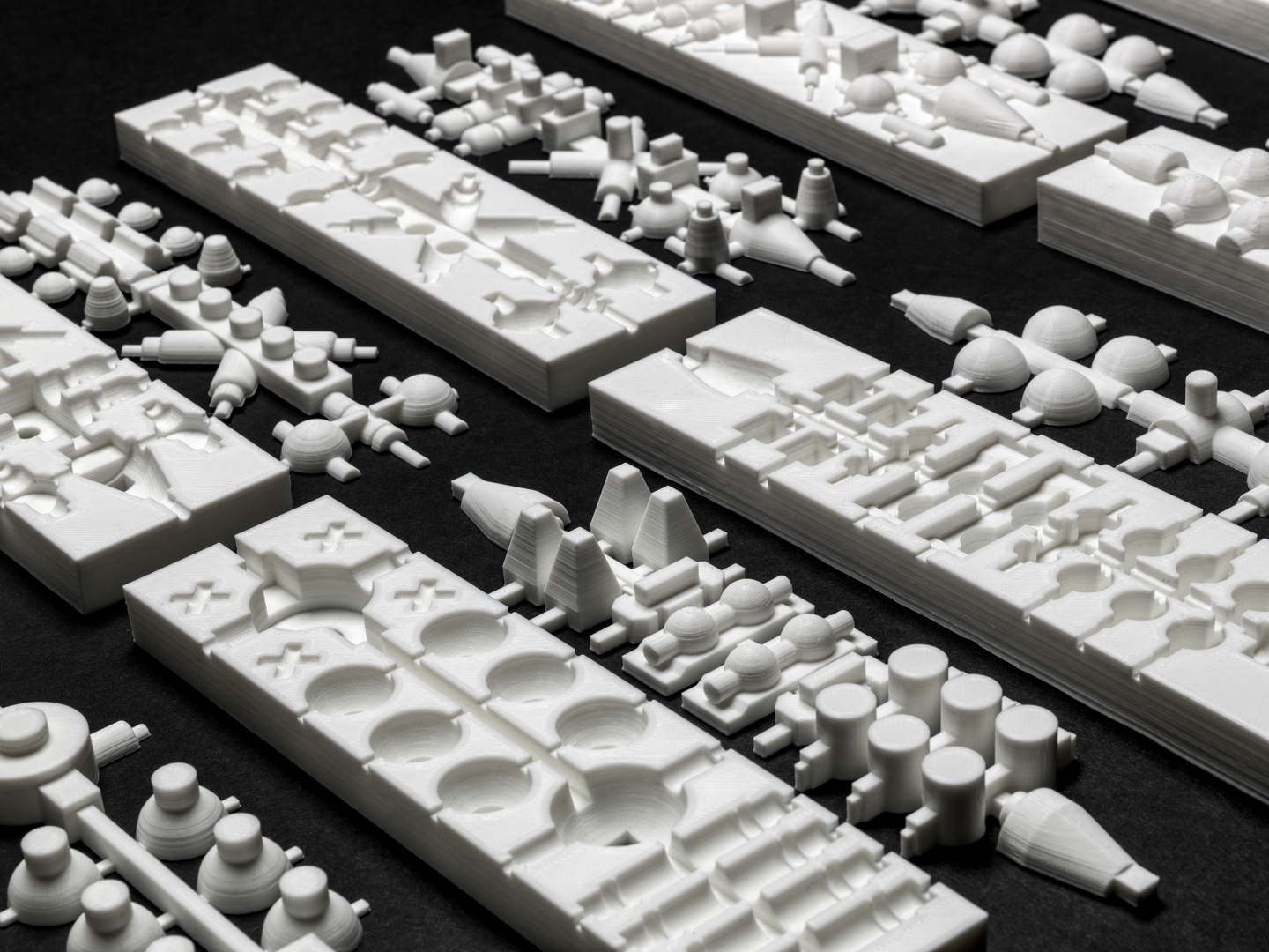 Abstract, white 3D printed objects arranged on a black background