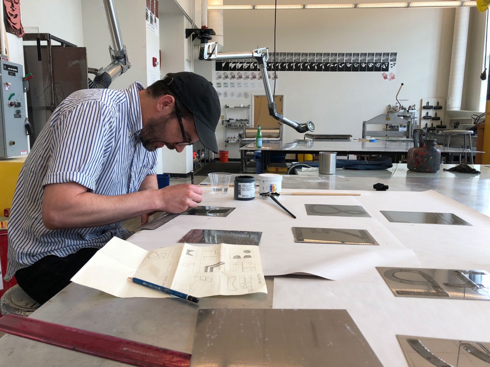 Artist Ben Edmiston working on etching plates in the print shop.