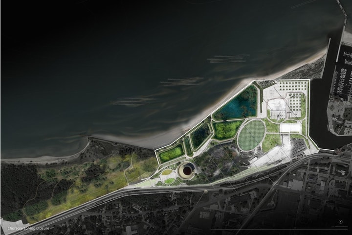 An architectural site plan showing a waterfront landscape development along a dark coastline. The highlighted site features green wetlands and retention ponds, curved pedestrian pathways, a large circular structure, a central oval lawn, and paved plazas bordering an adjacent town and marina.