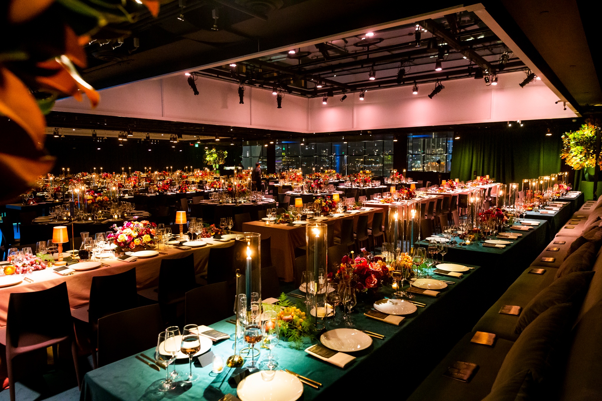 A photo of The Shed's Tisch Skylights event space decorated with tables, lighting, and floral arrangements for a gala dinner event. 