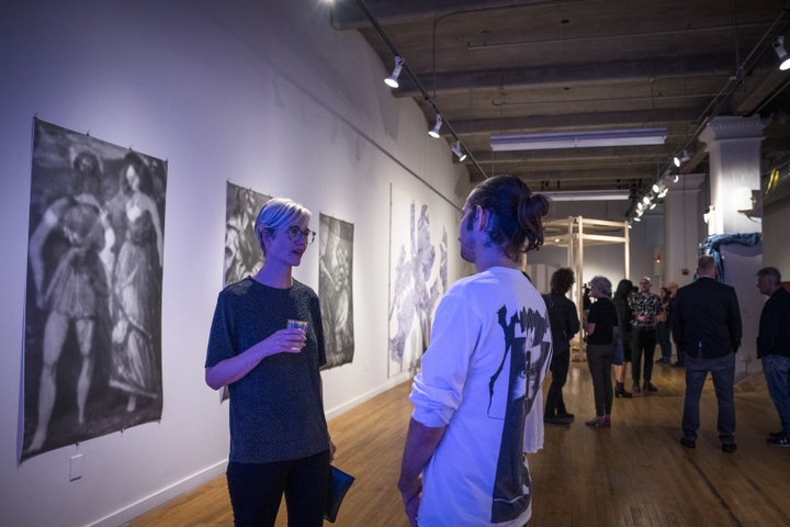 Cheryl Wassenaar speaks with a visitor in front of Seulki Seo's large abstract prints