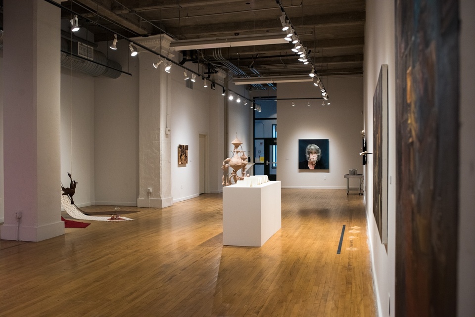 Alternate view of gallery space displaying book arts, fabric works, and a mixed media painting.