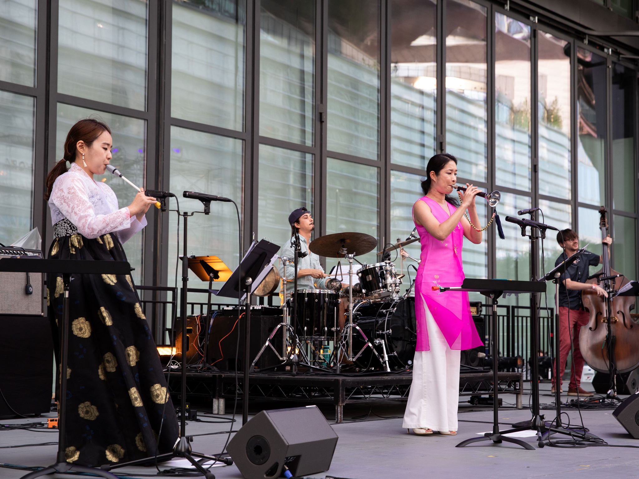 Women and men playing live instruments on a stage.