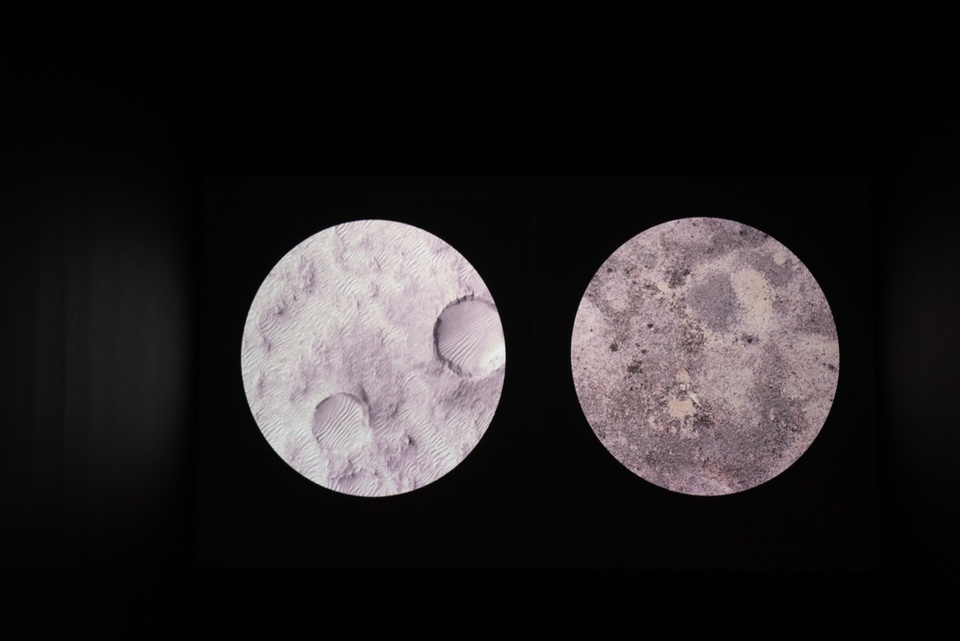 Two circular images of stone textures, resembling the surface of the moon, are set on a black background.