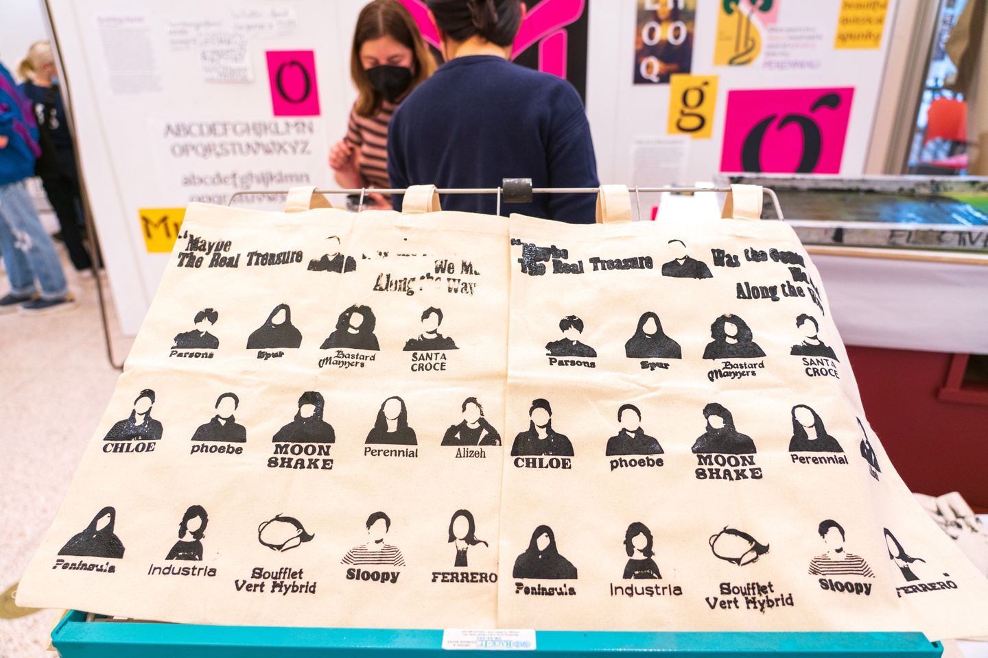 Screenprinted tote bags with students' silhouettes and a typeface sample below each.