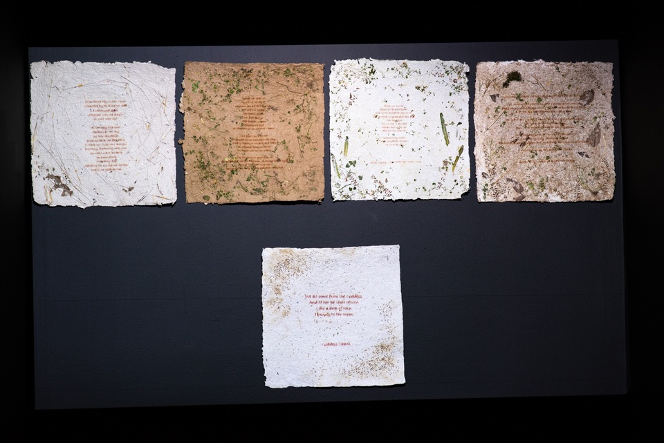 Five sheets of handmade paper inlaid with leaves and wildflowers with verses printed on them.