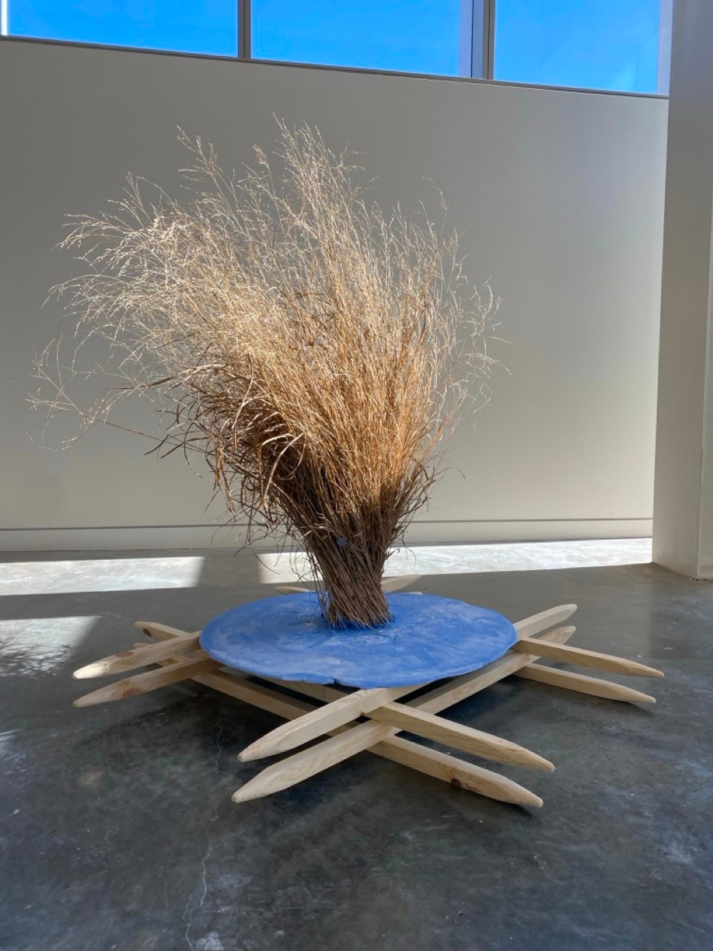 a sculpture with a wooden base and tall brush