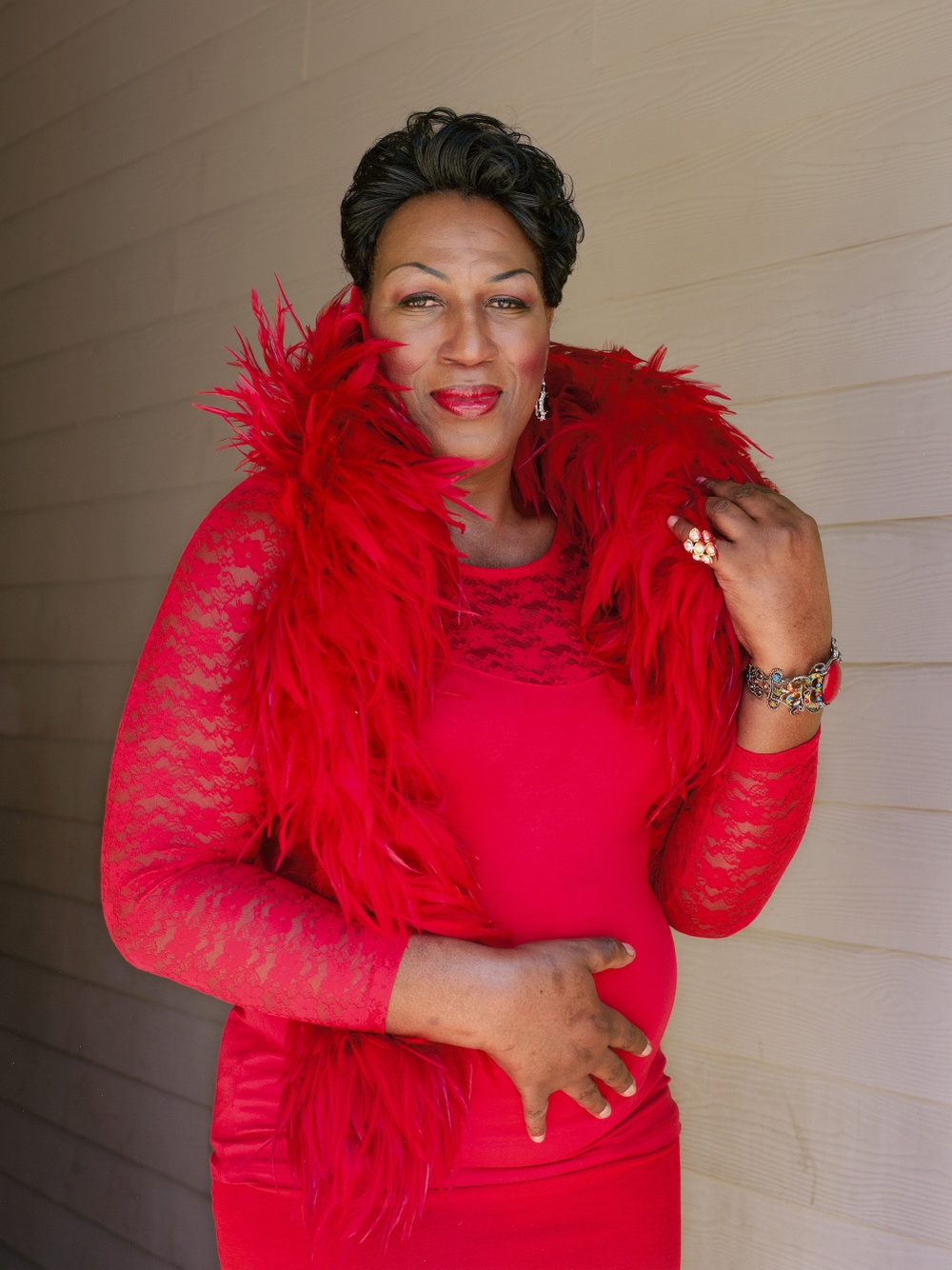 A Black woman wearing a red outfit smiles at the camera.