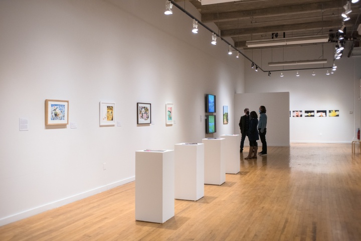 Open gallery space displaying prints and magazines on plinths.