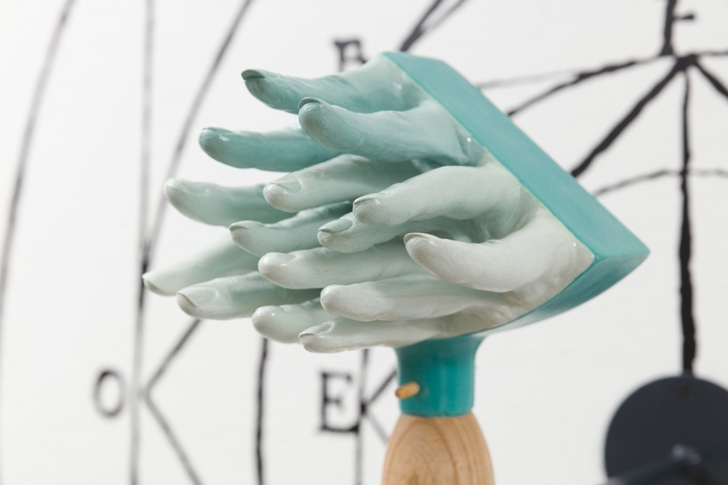 A light blue sculpture of multiple fingers protruding through a triangular shape