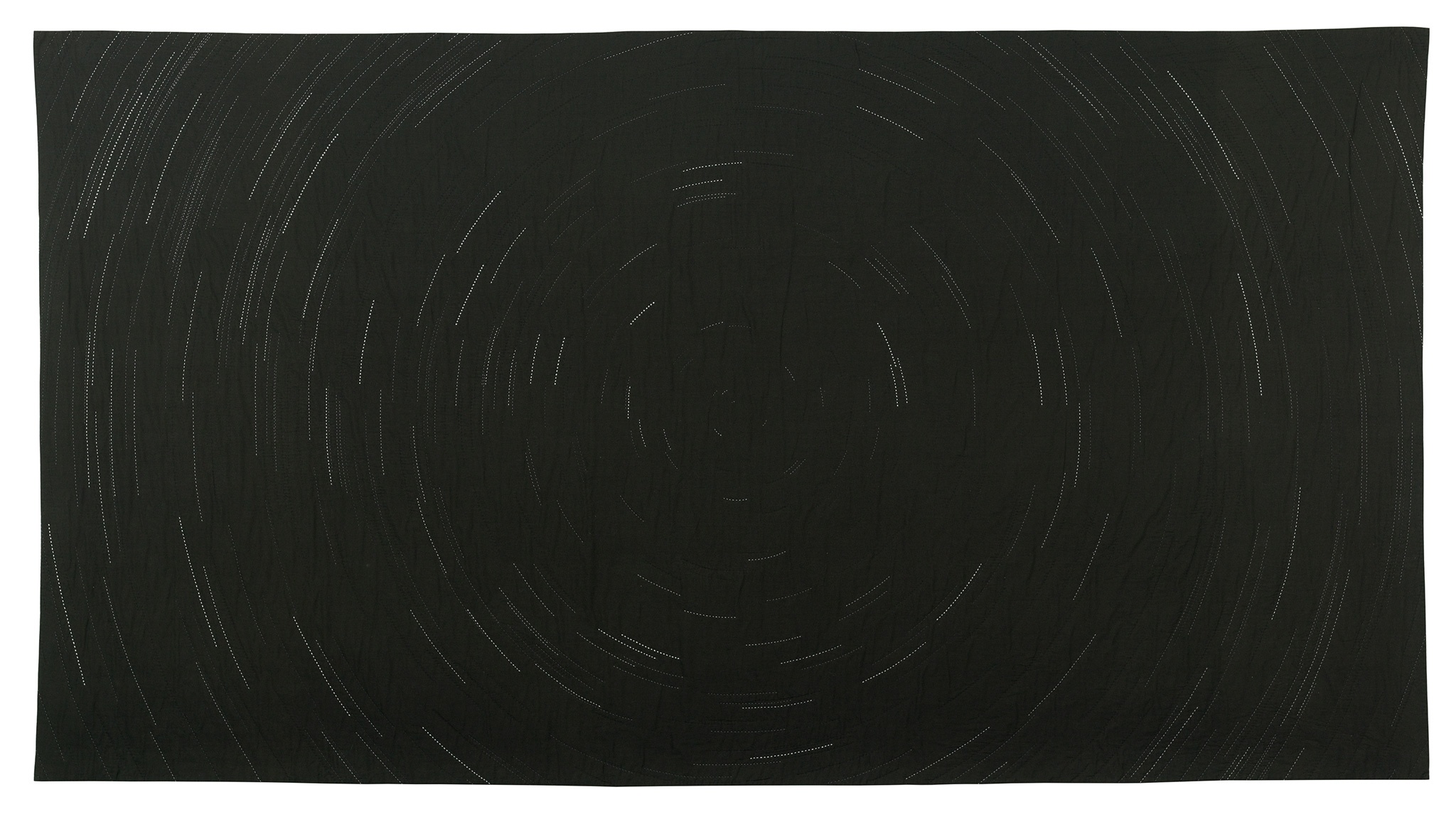 Against a black background are faint white and gray lines forming broken concentric circles that imply movement through space.