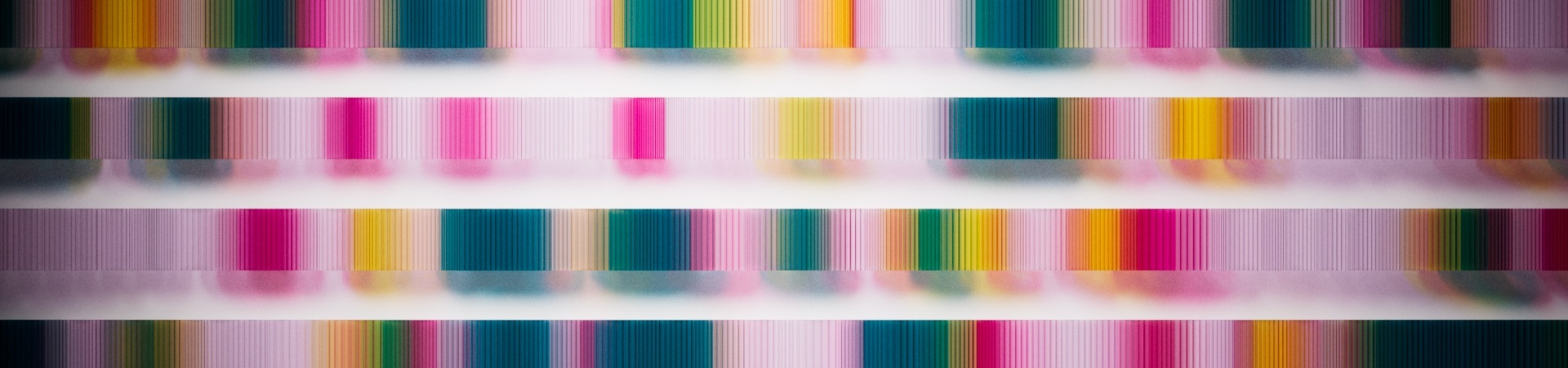 Horizontal rows of vertical bands of translucent color, ranging from pinks to yellows to white and green