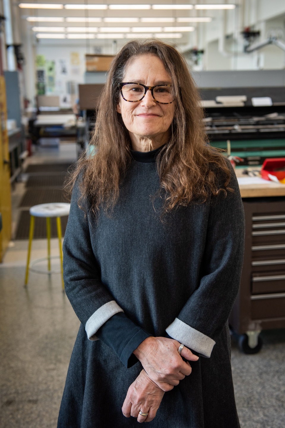 Photo of Amy Hauft in front of a metal railing with city buildings in the background.