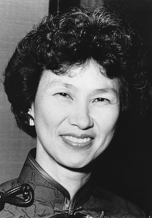A black and white close-up photograph of a smiling middle-aged Asian women.
