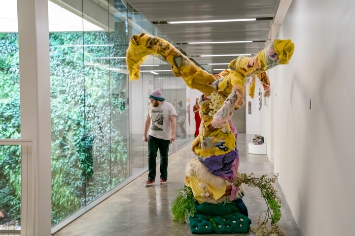 Walkway between studios and the interior courtyard, which contains a living green wall. A large-scale felt sculpture has been placed in the hallway.