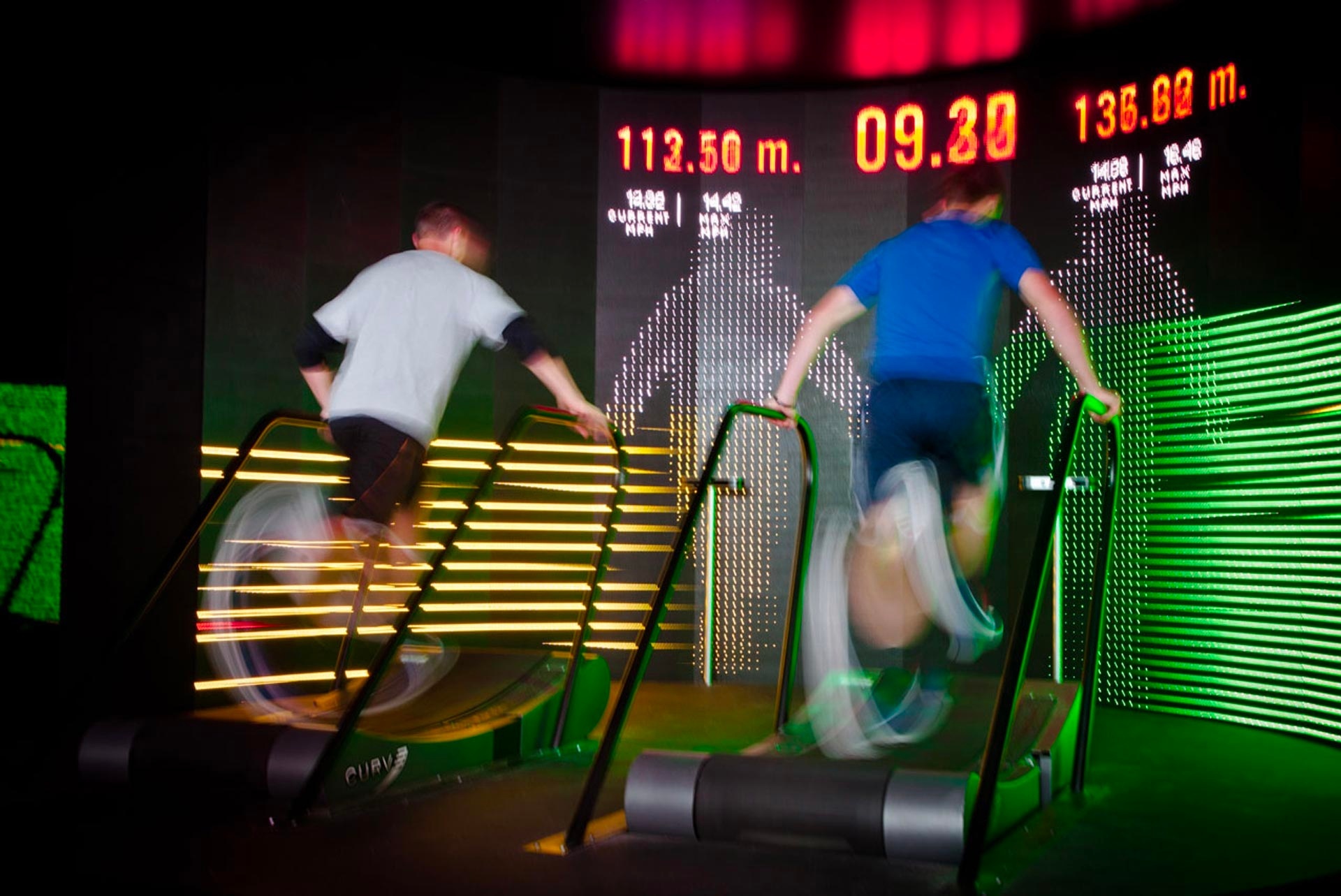Two participating runners on treadmills, competing for the furthest distance