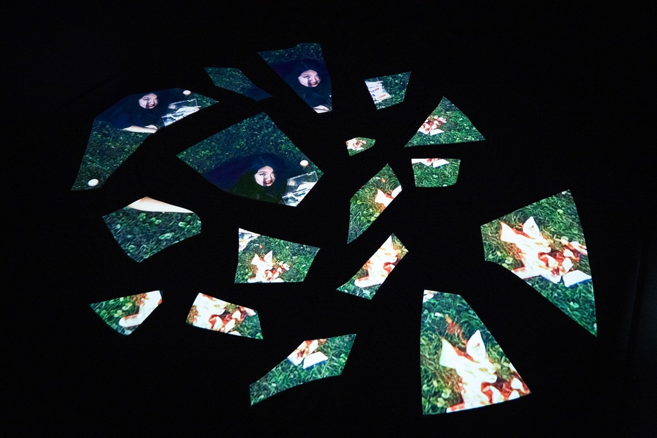 Sharlene Lee's floor projection on fractured broken flat pieces in a dark room