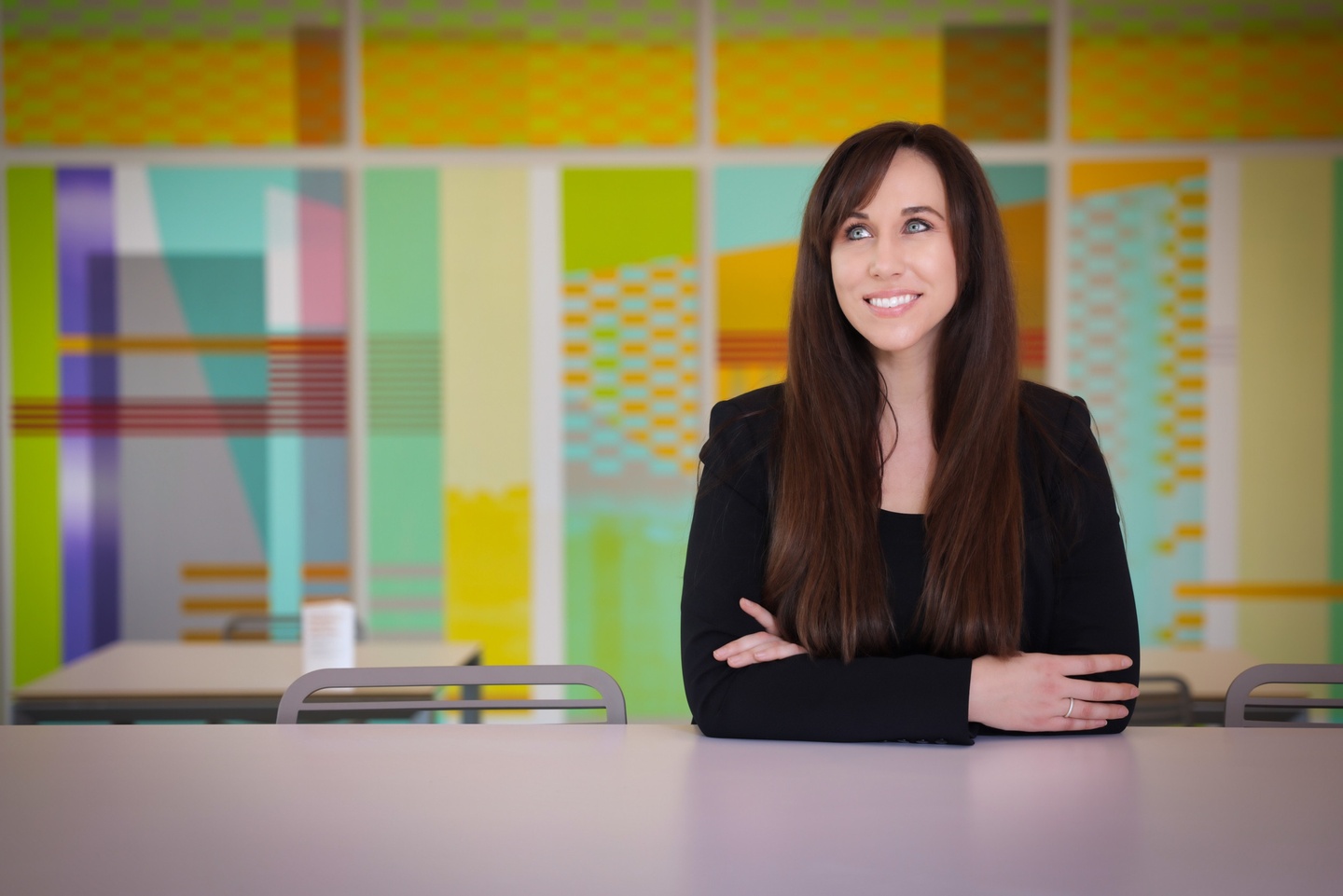 Portrait of Constance Vale sitting in front of a brightly colored mural.