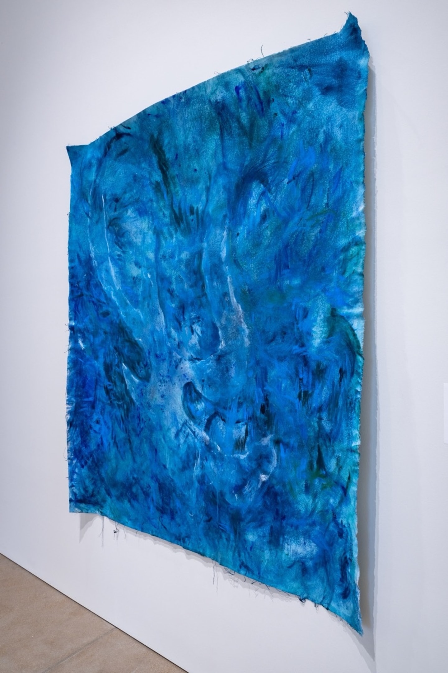 shades of blue paint and ink swirled on a canvas