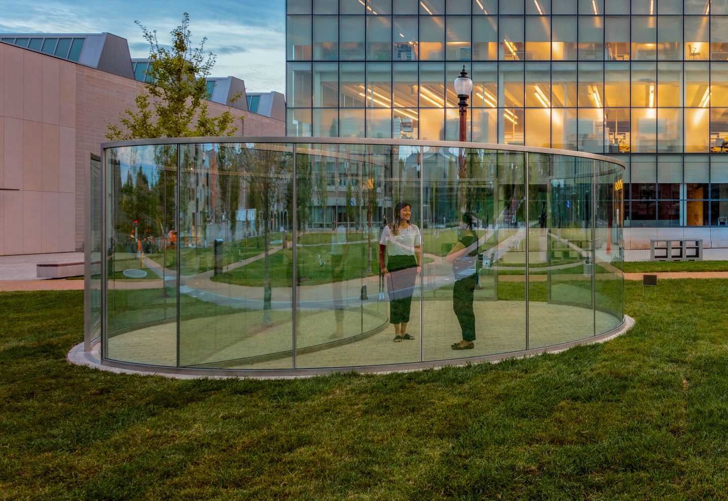 Two people stand inside a transparent pavilion