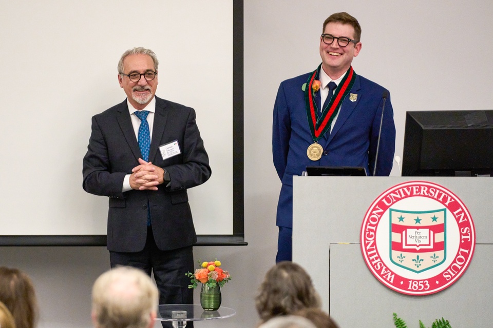 Two men, one wearing a medallion.