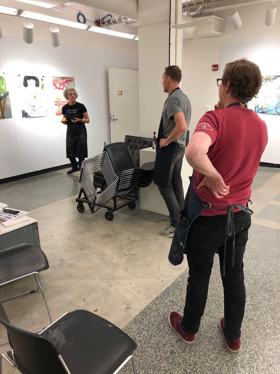 Lisa Bulawsky, David Humphrey and Tom Reed observe prints on the wall