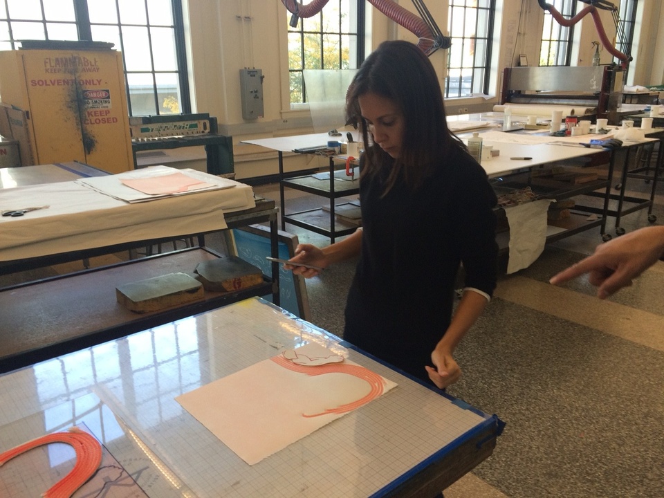 Artist working on print on the table, arranging collage