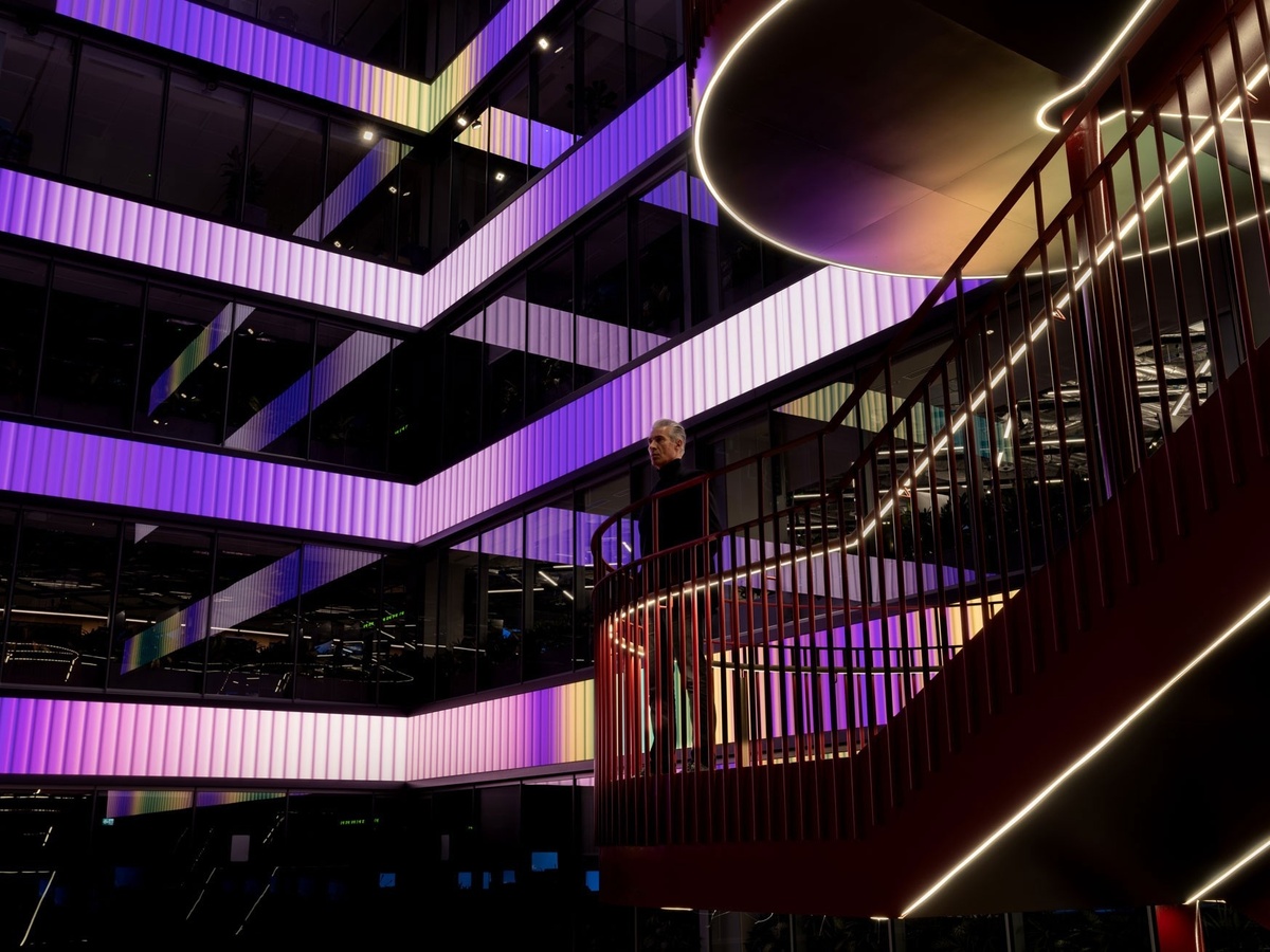 View of lobby with floorplates of digital content, in a pink to purple gradient