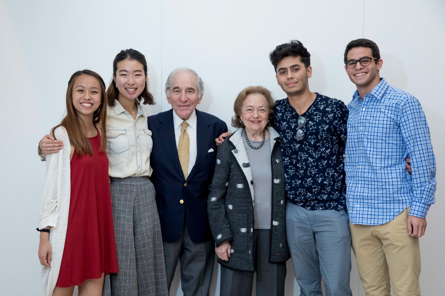 Four young adults and two older adults pose for a group photo.