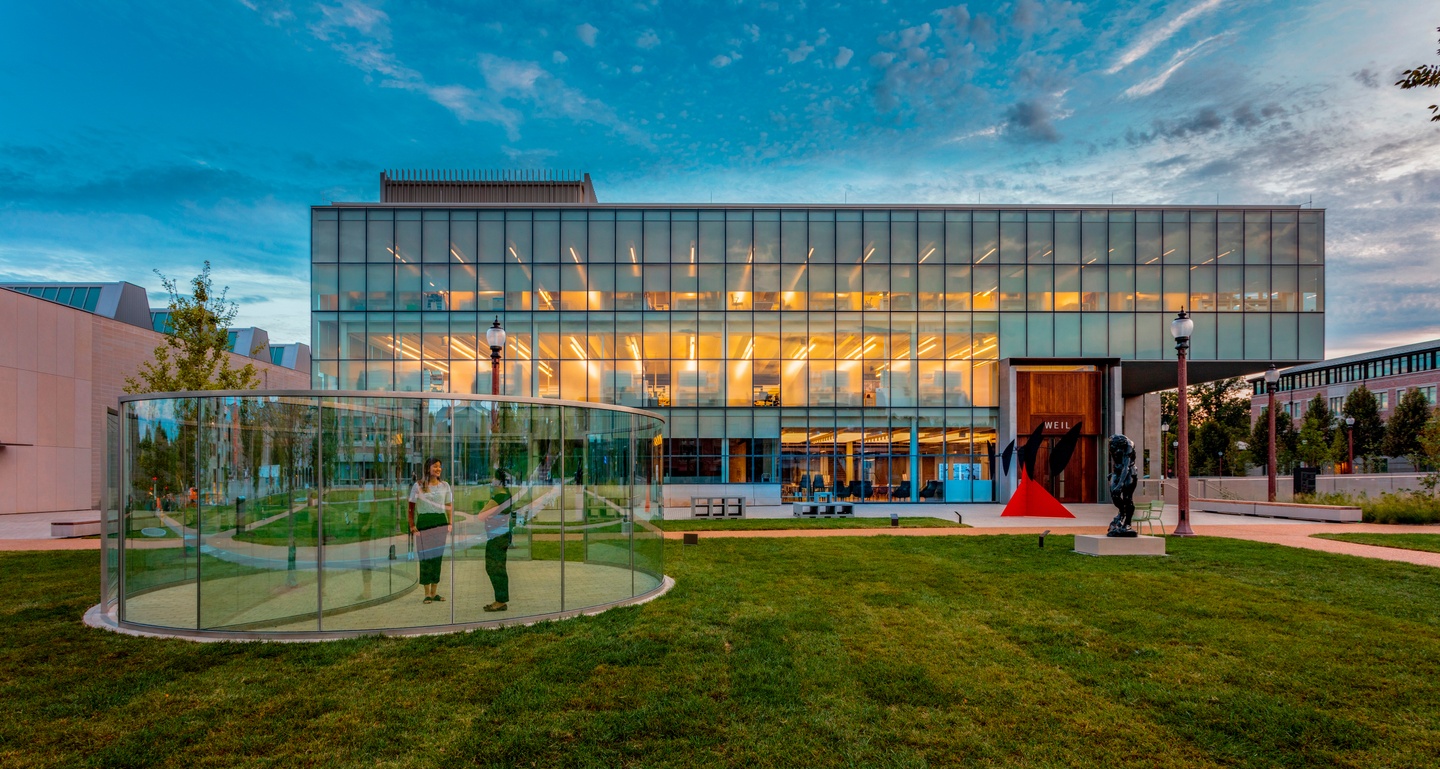 image of Weil Hall with blue sky in the background and people walking around