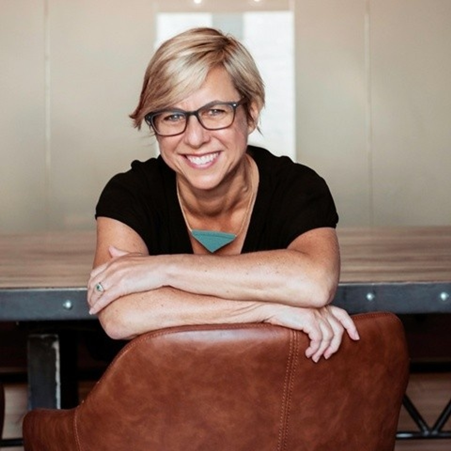 Linda Samuels smiling with arms folded over the back of a chair
