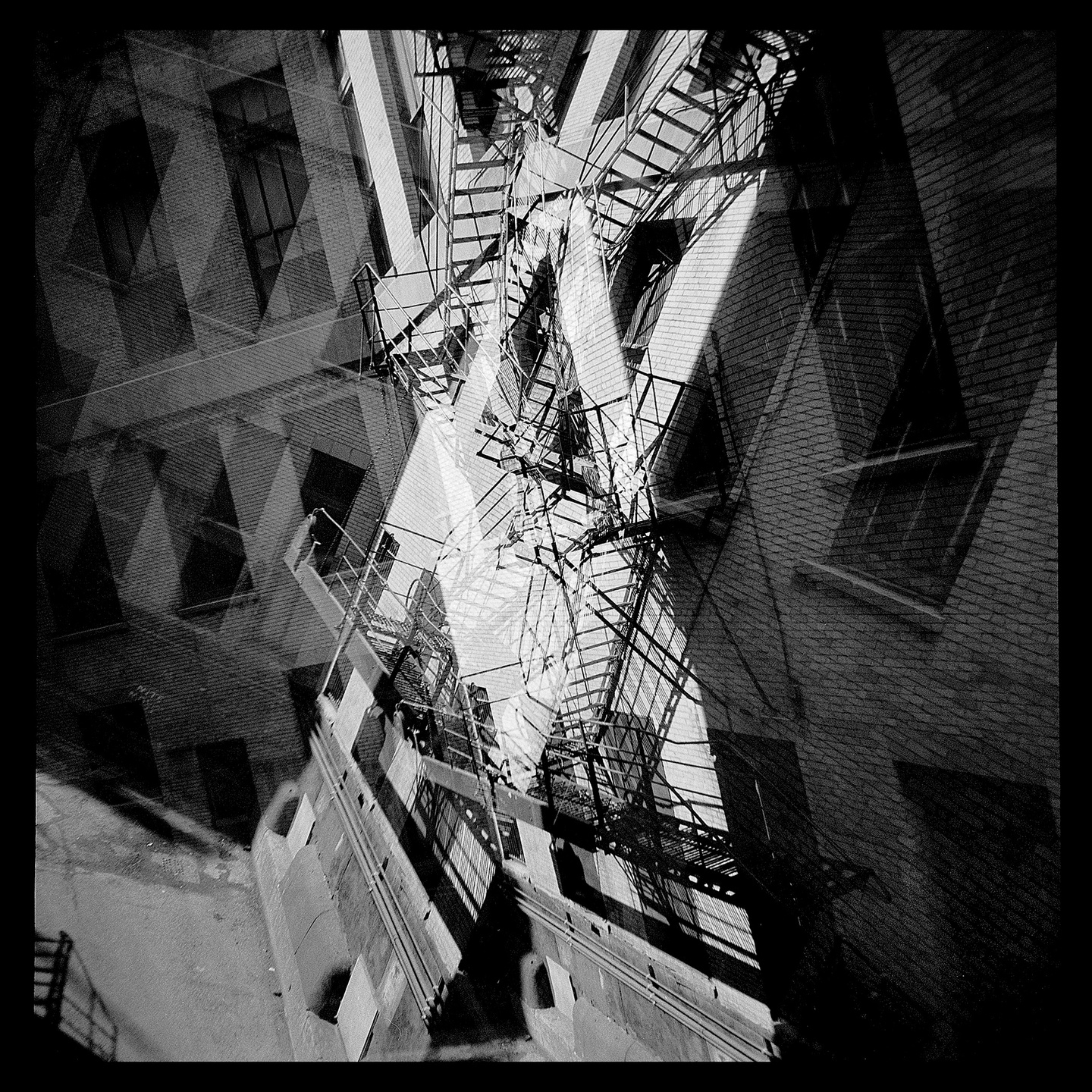 Black and white abstract photograph of a city block and fire escape stairways