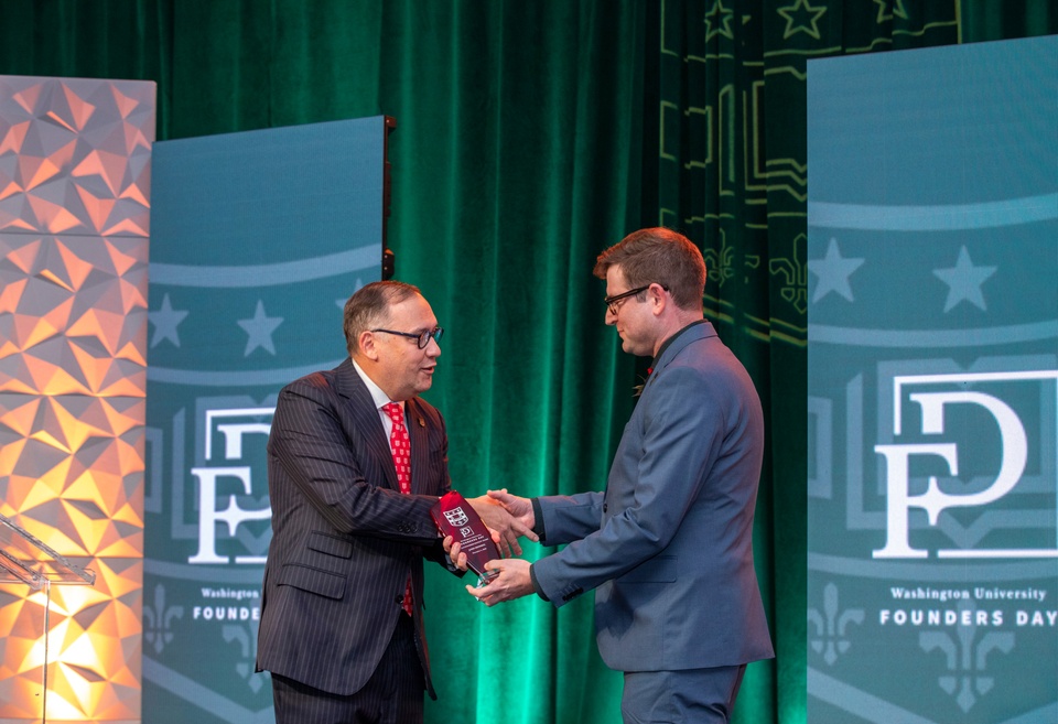 Chancellor Martin and John Hendrix shake hands on stage.