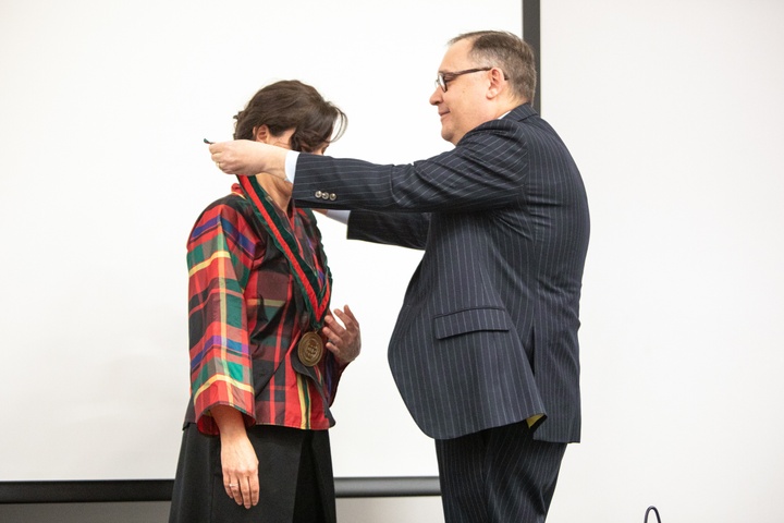 Man bestows medallion on woman.